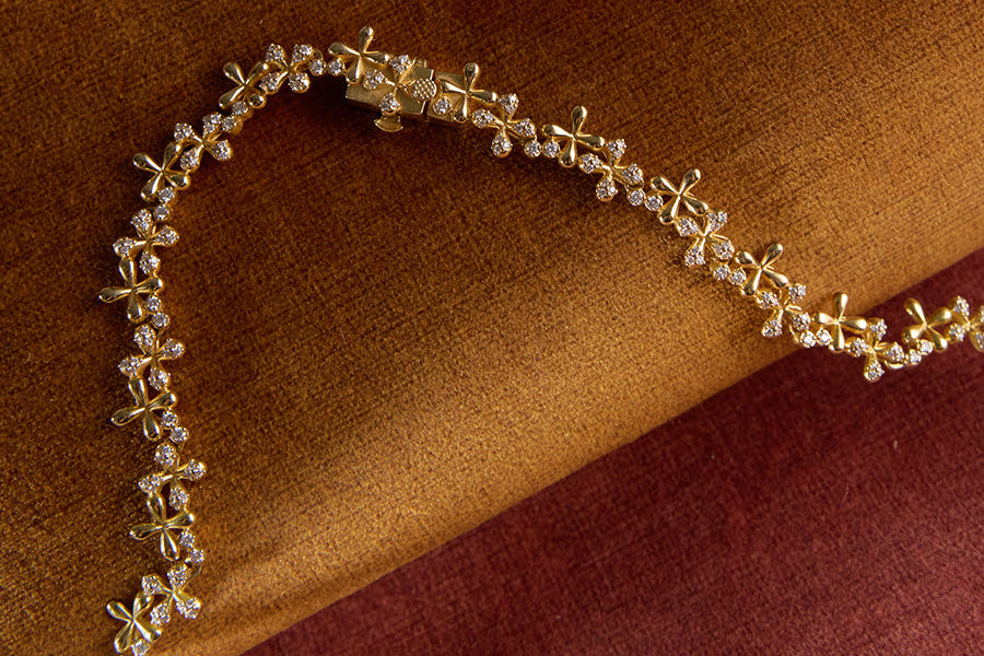 Gold bracelet with diamonds on a brown fabric background