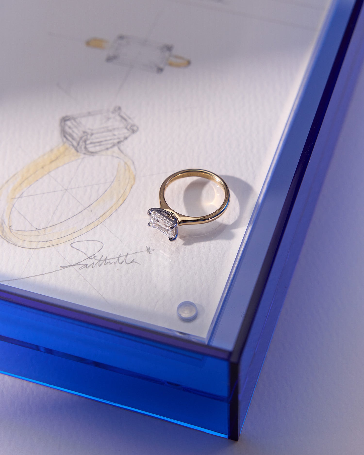 Emerald-cut East-West Engagement Diamond Ring in yellow gold with white gold claws, a modern yet timeless elegant design.