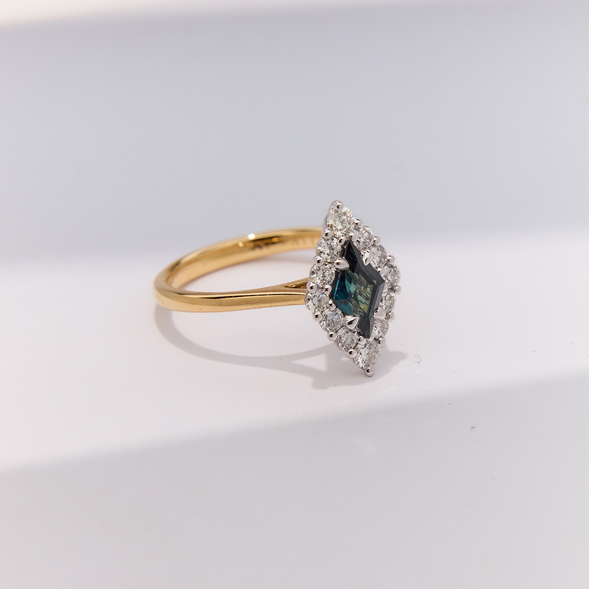 Adeline-inspired sapphire ring featuring lozenge blue sapphire and diamond halo