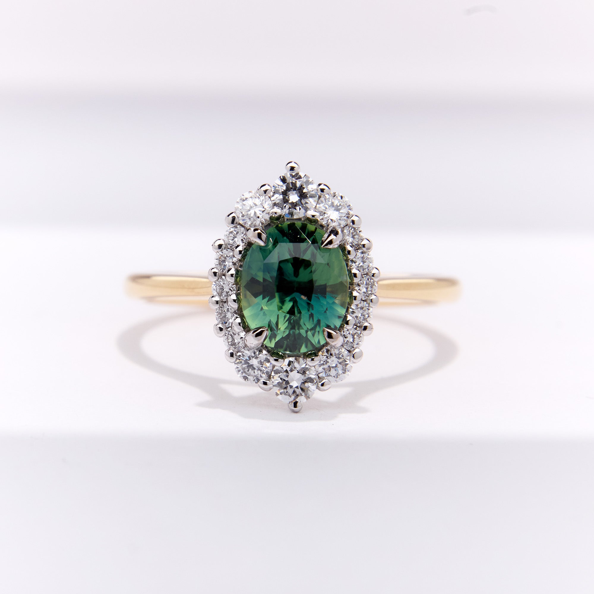 Parti Teal Sapphire Engagement Ring with oval sapphire and diamond halo in two-tone gold