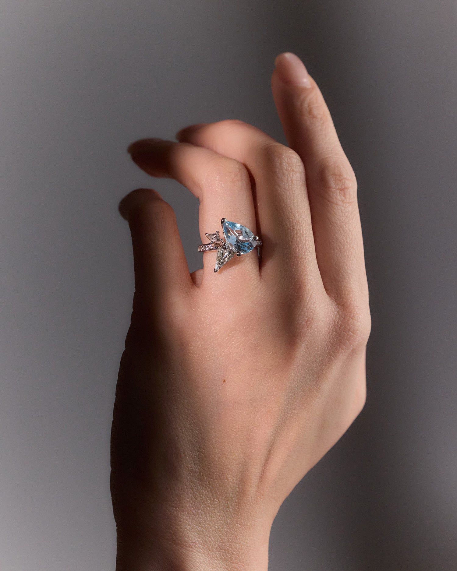 9k white gold Blue Bouquet Ring with topaz, aquamarine & diamonds, inspired by floral elegance, perfect for timeless style, worn on hand model.