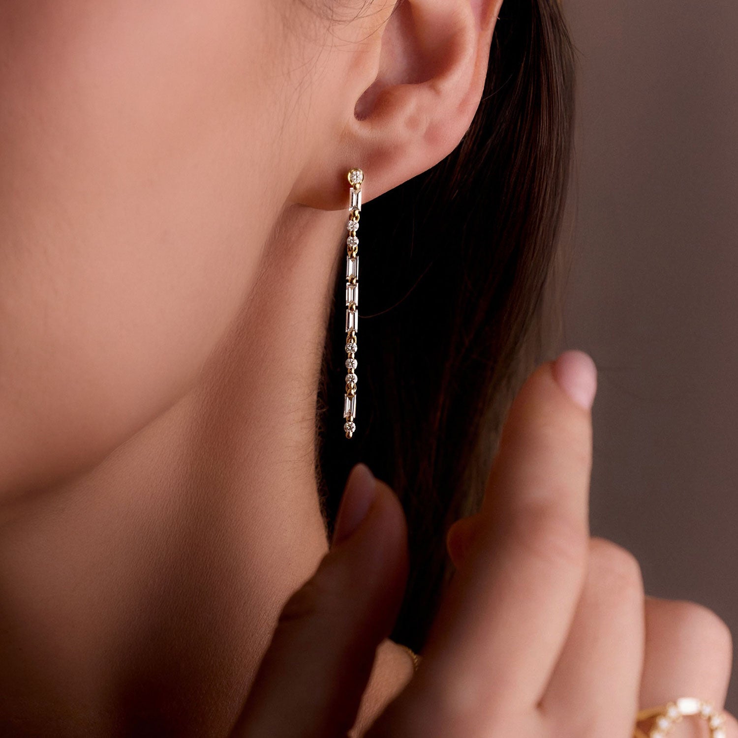 Faith Jewels Yellow gold drop earrings with round and baguette diamonds spelling “LOVE” in Morse code.