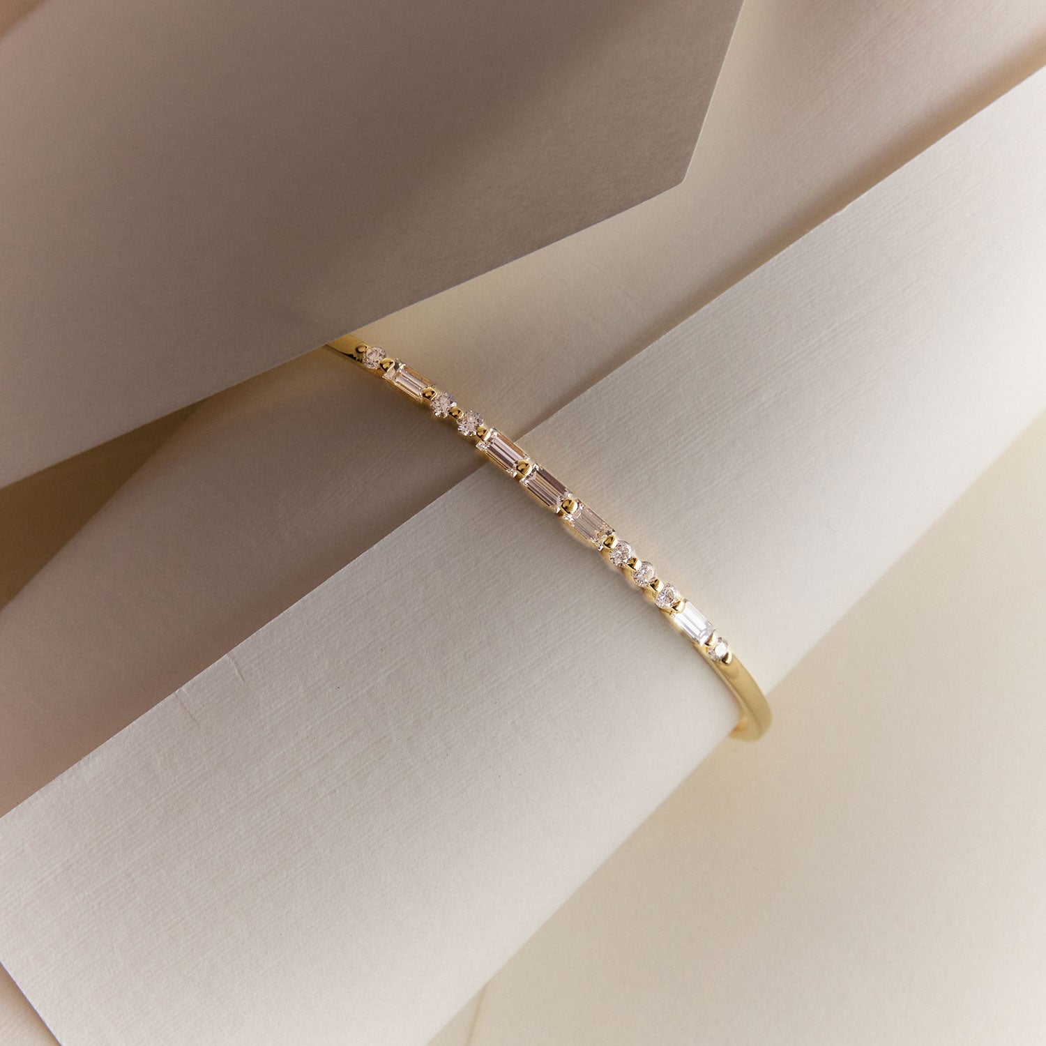 Faith Jewels 18k Yellow gold bangle with round and baguette diamonds spelling “LOVE” in Morse code.