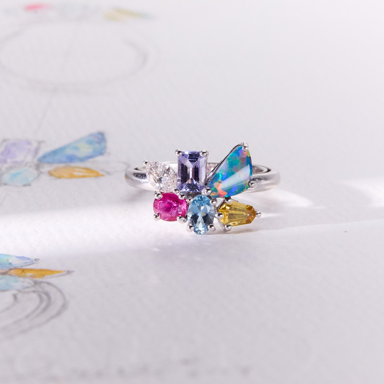 Hazel birthstone white gold band ring featuring aquamarine, diamond, opal, ruby, citrine, and tanzanite arranged in a colourful design, symbolizing family