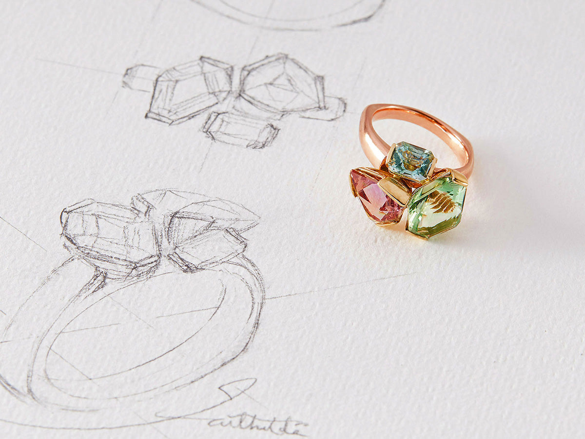 Colorful gemstone bouquet ring on a white background with sketches of the ring.