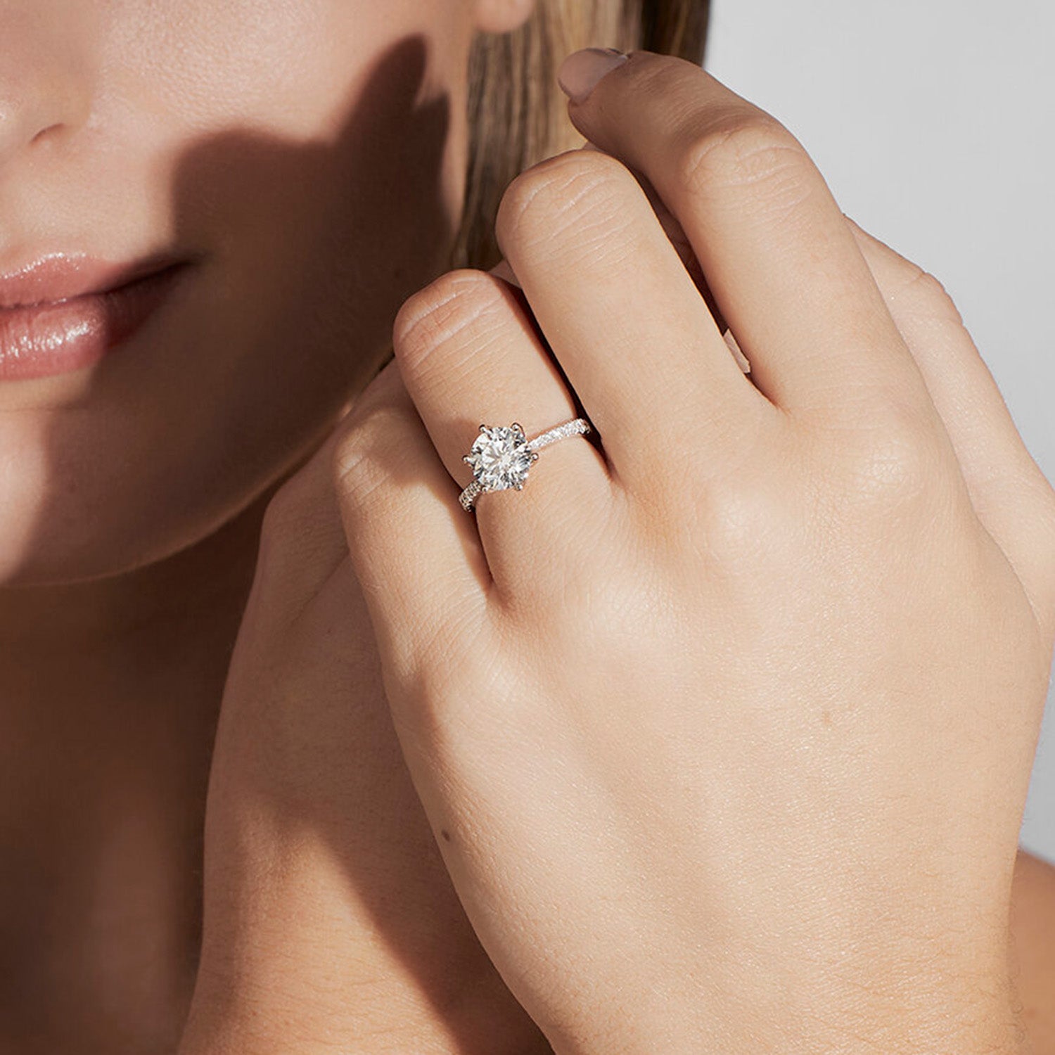 Faith Jewels Clarissa white gold engagement ring featuring a round brilliant center diamond with pavé-set side stones and a six-prong setting