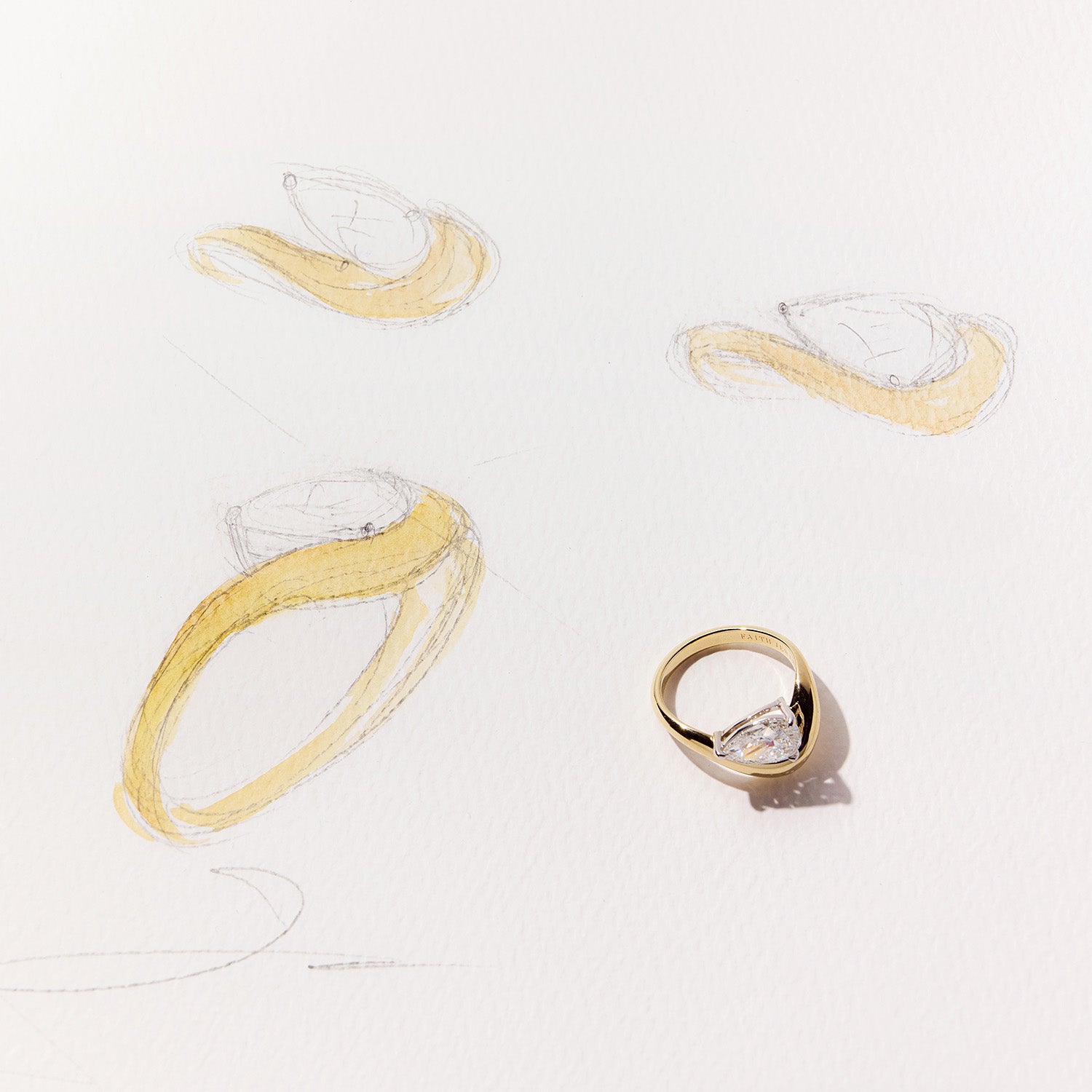 FJ Engagement Ring featuring a pear cut diamond set in a bold, curved yellow gold band with a sculptural, contemporary design