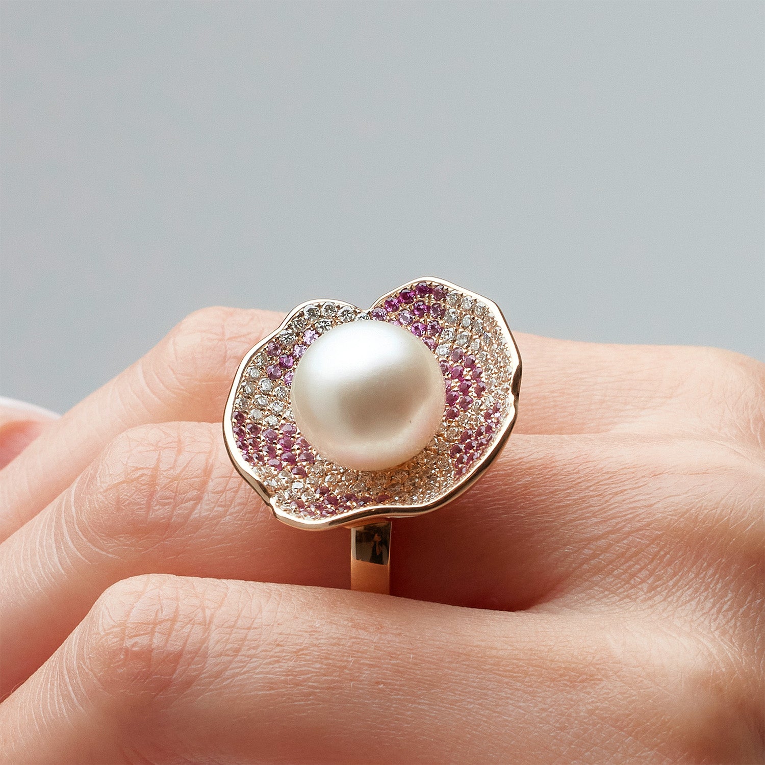 Faith Jewels Rose gold ring and earrings set with a central pearl, pink and white pavé diamonds, and petal-like design.