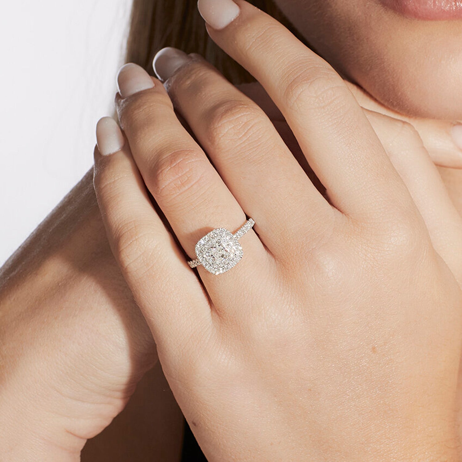 Faith Jewels Hepburn diamond engagement ring with a round brilliant-cut diamond center, double diamond halo, and pavé diamond band