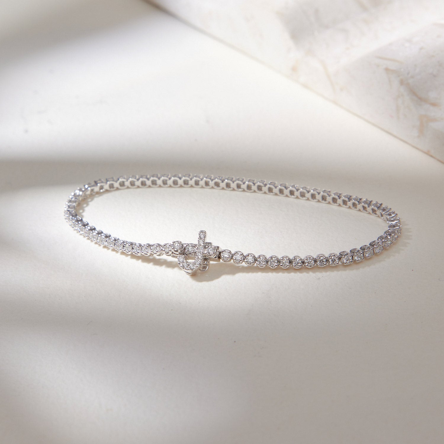 Faith Jewels bespoke initial diamond tennis bracelets in white gold, each featuring a unique clasp shaped as a letter J — set with round brilliant-cut diamonds