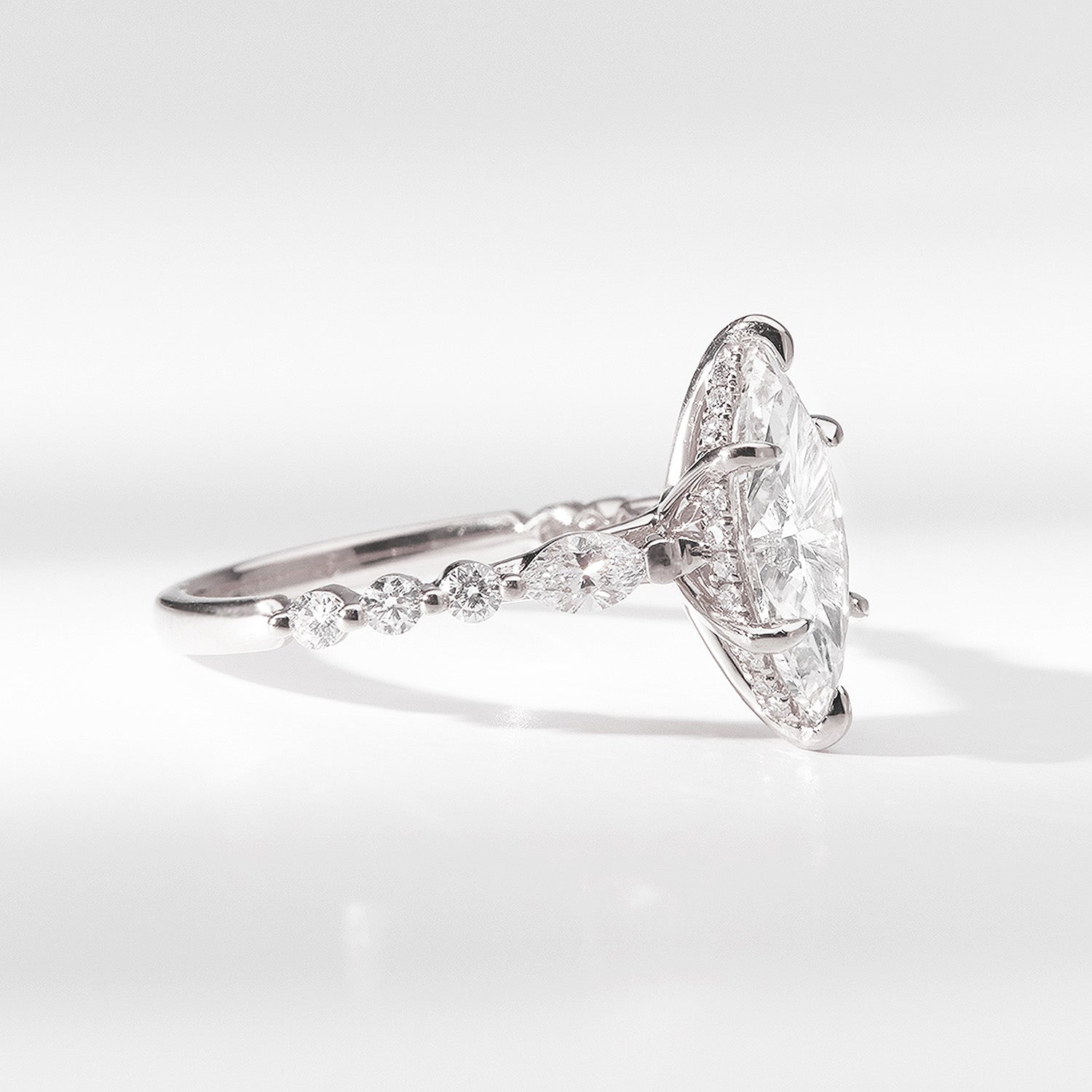 Julia Engagement Ring marquise-cut diamond engagement ring featuring a brilliant center stone with a gold band adorned with round accent diamonds by Faith Jewels