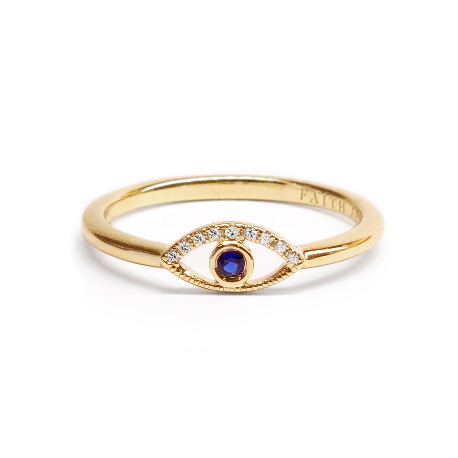 Faith Jewels Protection Ring featuring a yellow gold band with an evil eye design, accented by white diamonds and a central blue sapphire.