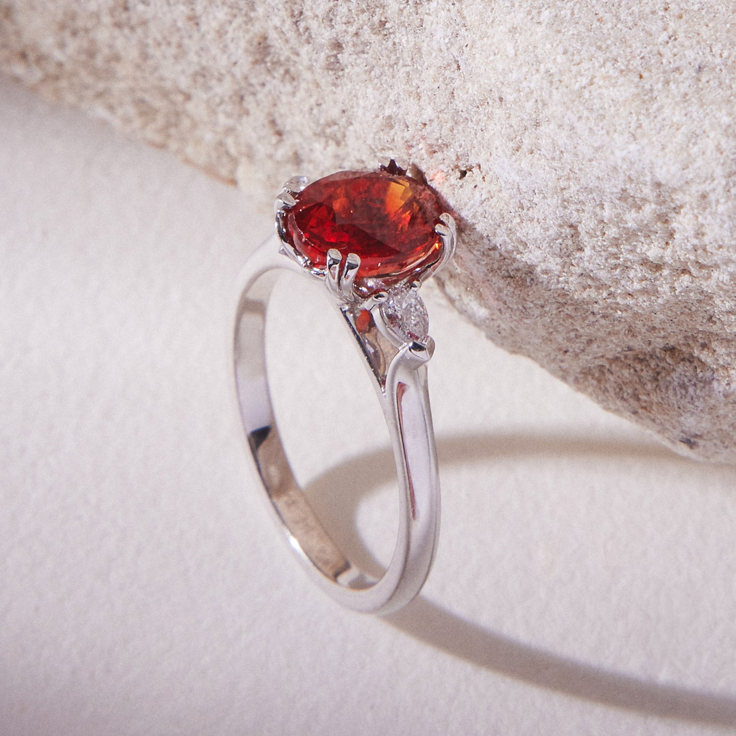 Sheree trilogy engagement ring featuring an orange round-cut sapphire flanked by pear-cut white diamonds in white gold band