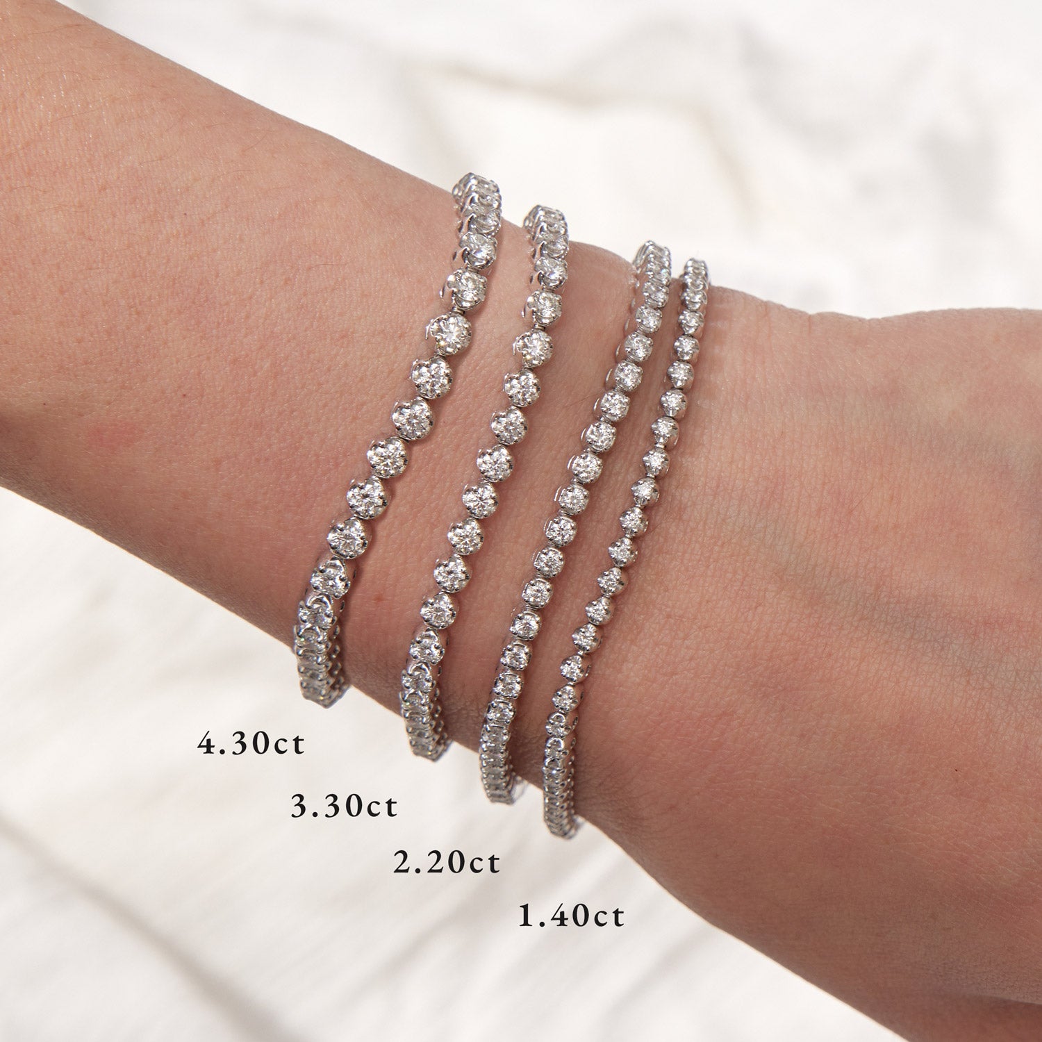 Faith Jewels bespoke initial diamond tennis bracelets in white gold set with round brilliant-cut diamonds in 4.30 ct, 3.30 ct, 2.20 ct and 1.40 ct