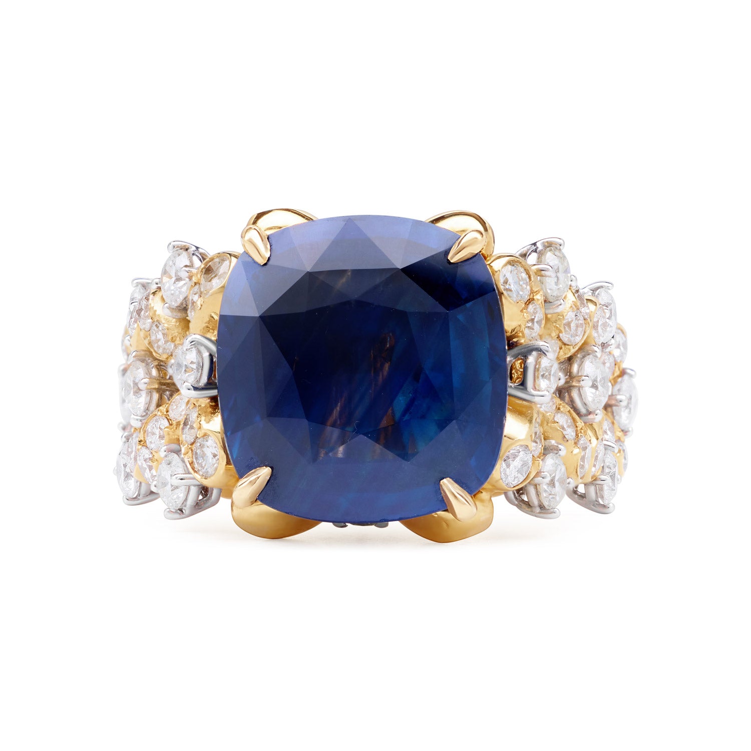 A luxurious ring featuring a royal blue Ceylon sapphire, surrounded by a floral wreath of golden florals with white diamonds, all in 18k yellow gold.