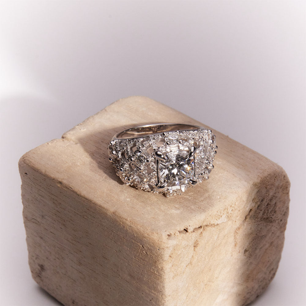 Faith Jewels White gold Pantheon Ring with a 2ct cushion-cut diamond center, surrounded by princess and round diamonds in an intricate lattice design.