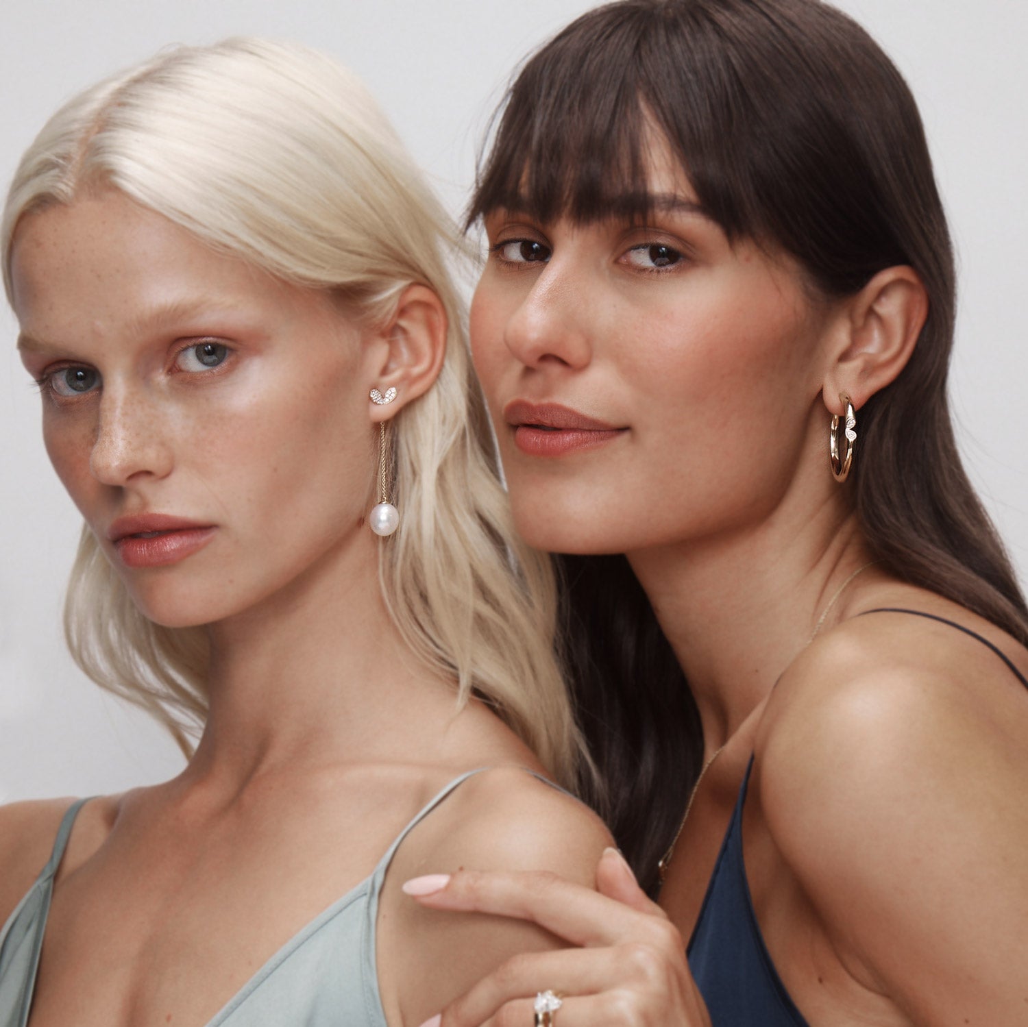 Faith Jewels curved 9k white gold hoop earrings worn next to pavé diamond stud earrings with pearl enhancers