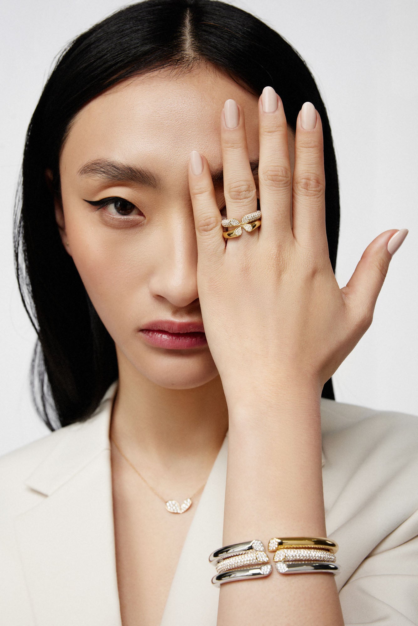 Faith Jewels two-tone 18k gold bangle with 0.20ct pavé diamonds, featuring a heart-shaped lily petal design and hinge closure, worn with matching necklace and rings