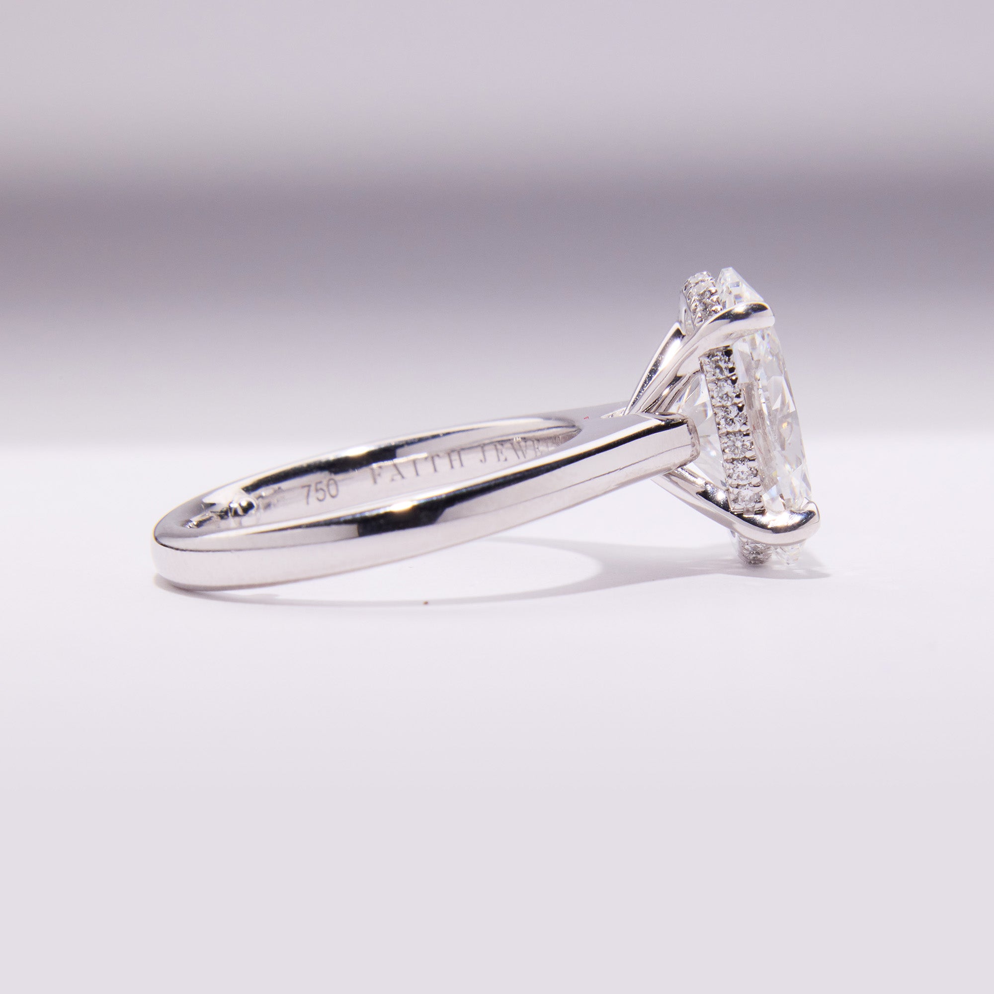 18k white gold engagement ring with 3.72ct oval-cut diamond, elegant band, with hidden halo.