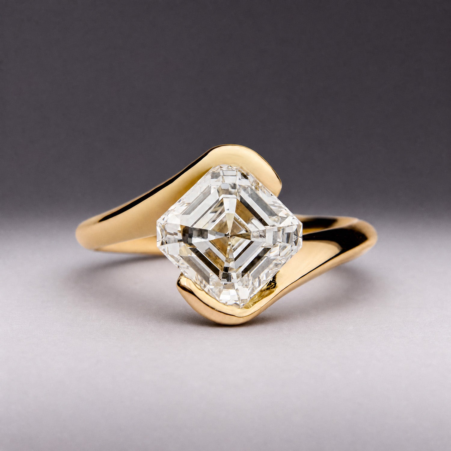 Asscher-cut diamond engagement ring in polished yellow gold with curved split band