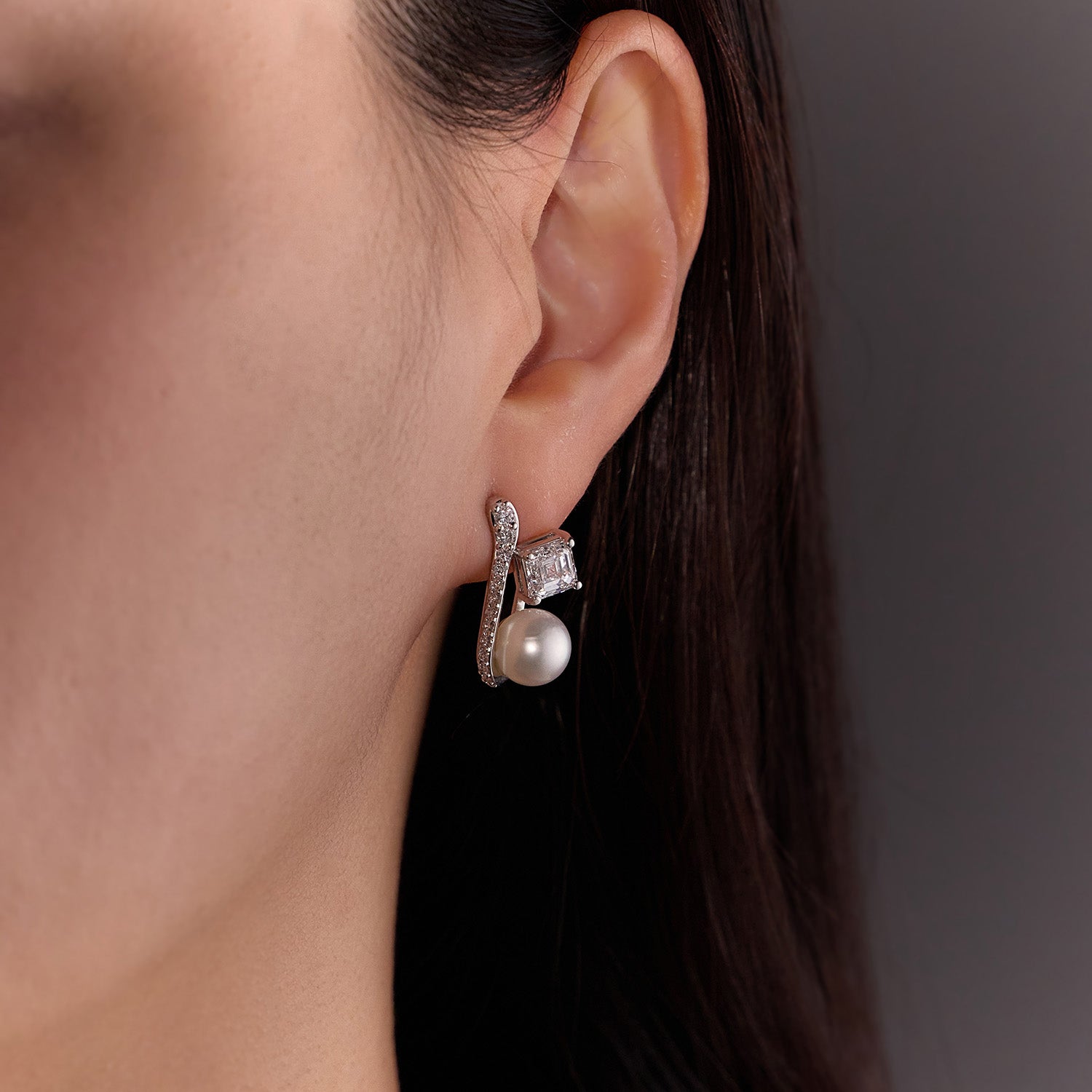 Pearl and Diamond Earrings featuring Asscher-cut diamonds and South Sea pearls with a sculptural pavé knife-edge design in white gold, worn on model