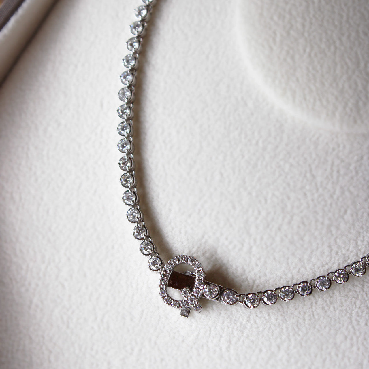 Bespoke graduated diamond tennis necklace with “Q” initial clasp, 12ct repurposed diamonds, elegant design.