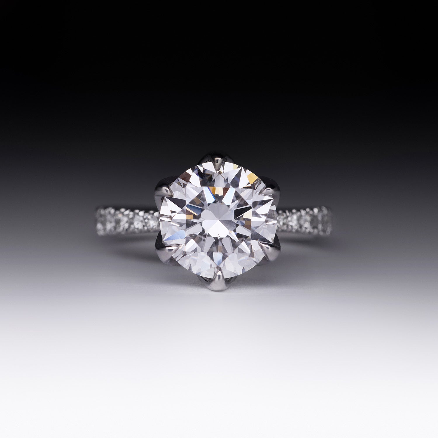 Sylvia diamond engagement ring with round brilliant-cut center stone and pavé band in white gold by Faith Jewels in top view.