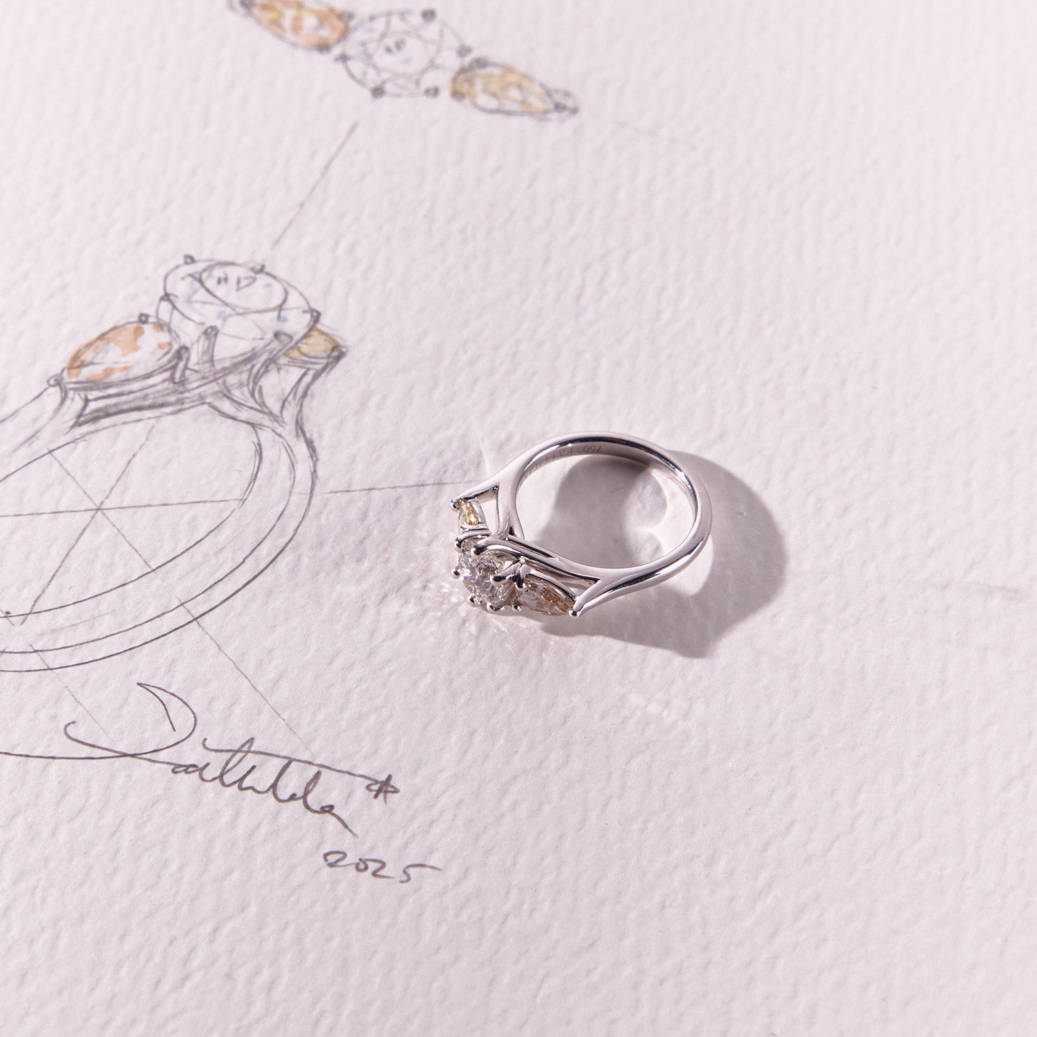 18k white gold Trilogy Engagement Ring featuring radiant round centre diamond and pear-cut pink & yellow side stones, timeless and modern.