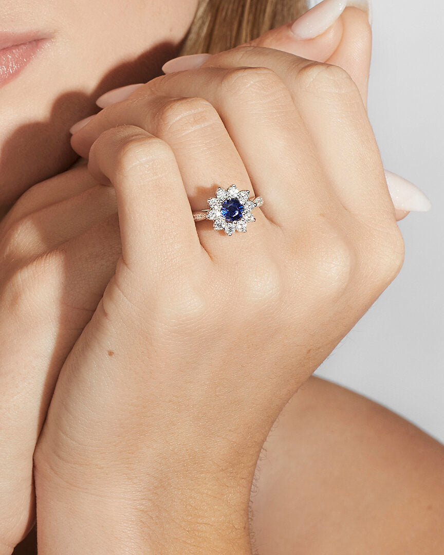 Faith Jewels Gina blue sapphire and diamond ring with a halo of brilliant cut diamonds surrounding a 0.50 carat blue sapphire, set in a half diamond grain-set band