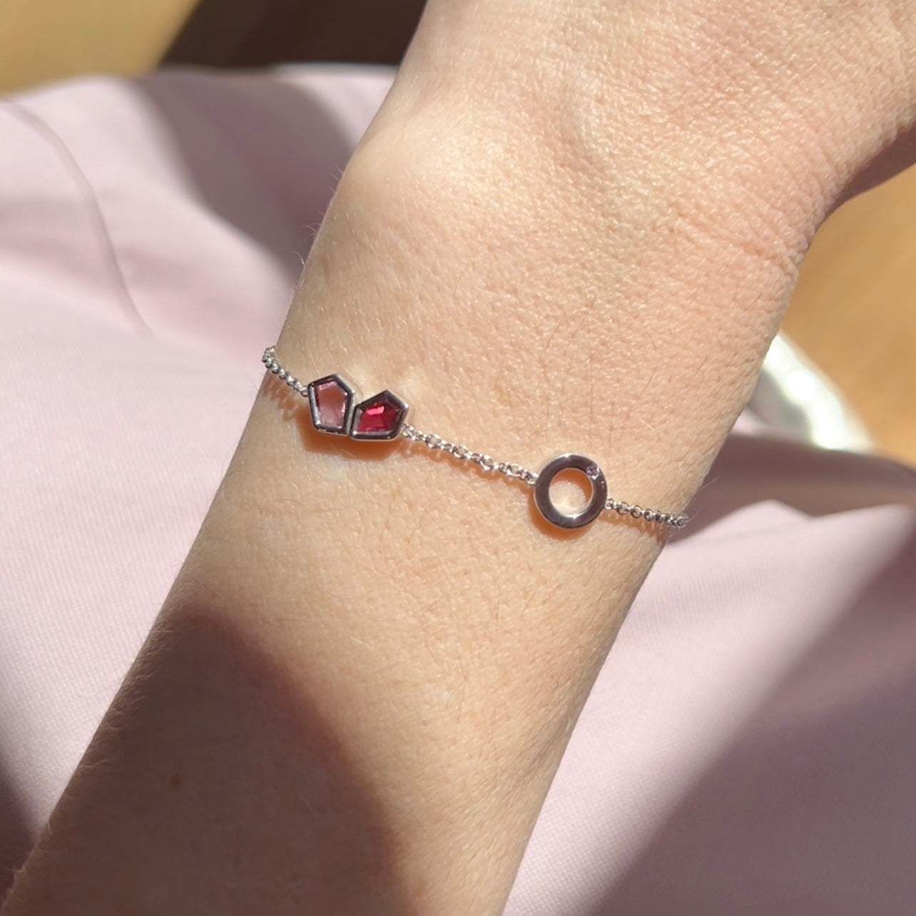 Faith Jewels Bespoke white gold bracelet with an “O” initial, birthstone accent, and heart-shaped spinels symbolising family and love.