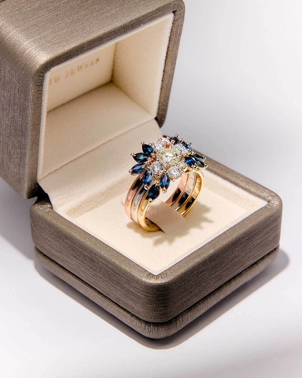 Custom and elegant three-generation heirloom ring set with diamonds and marquise blue sapphires in white, rose, and yellow gold in Faith Jewels box