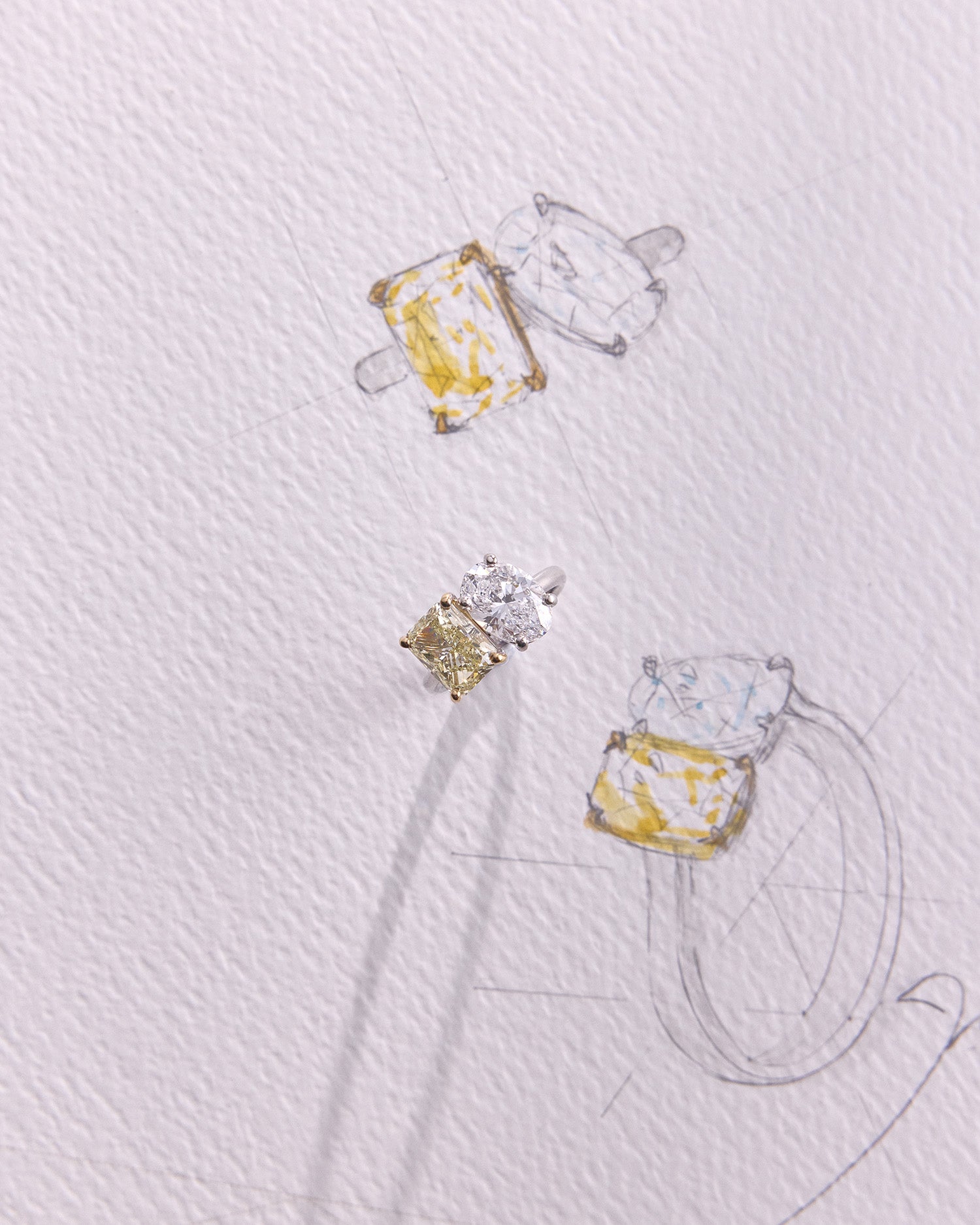 Two-stone diamond duetto ring with radiant and oval cut diamonds, set in polished 18k gold on sketch.