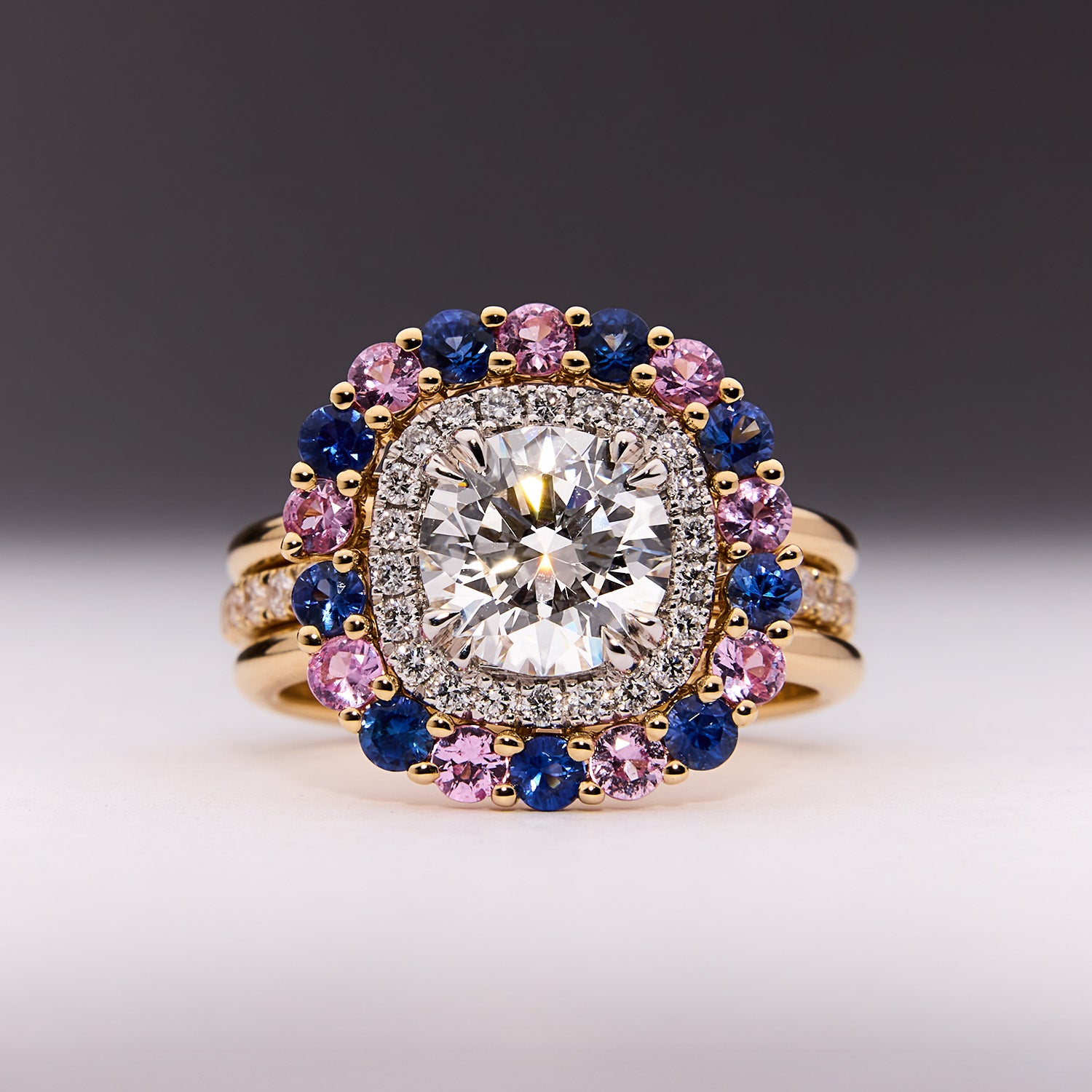 Diamond ring with blue and pink sapphire halo in yellow gold