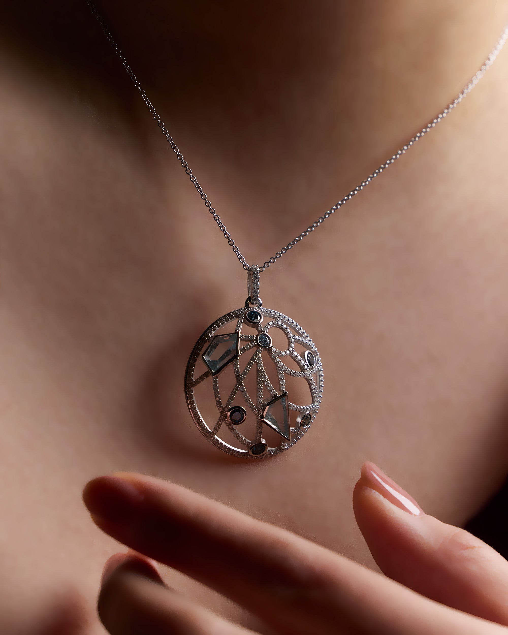 Custom Dome shape Pendant Necklace in 18k white gold with aquamarines, blue sapphires, and pavé diamonds on model's neck