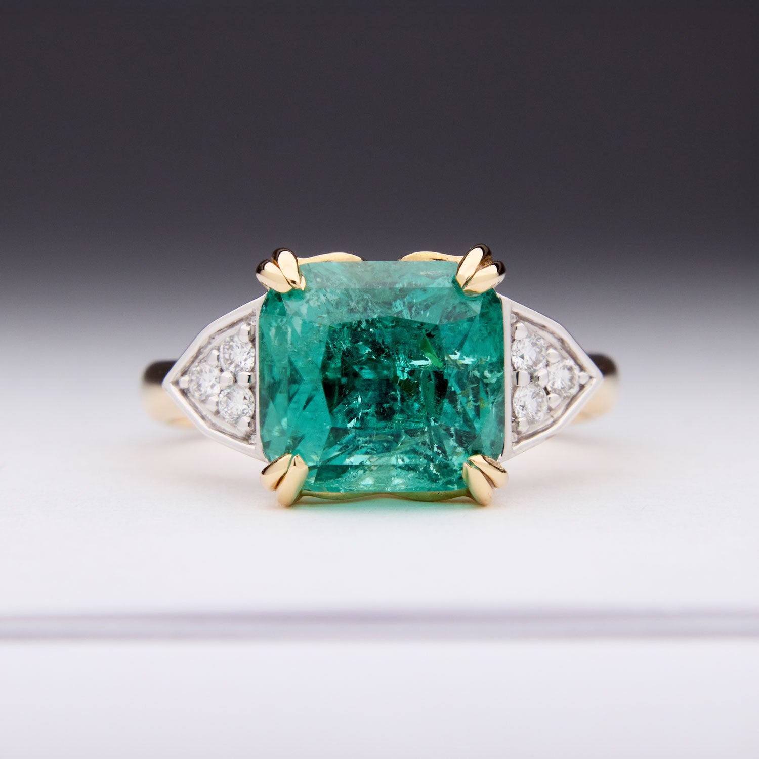 Paraiba Tourmaline Ring featuring a cushion-cut blue-green gem with diamond sides, crafted in yellow and white gold for timeless elegance