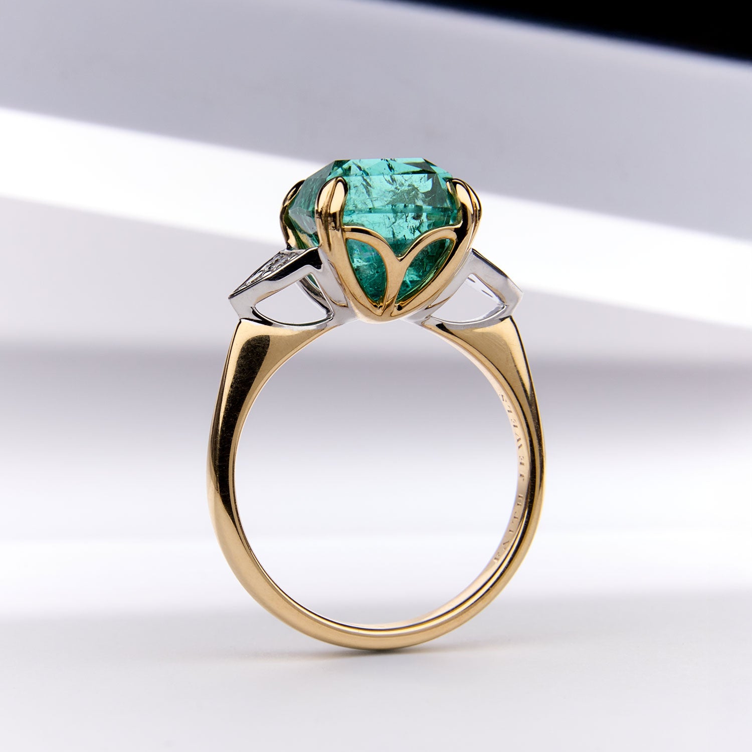 Paraiba Tourmaline Ring featuring a cushion-cut blue-green gem with diamond sides, crafted in yellow and white gold for timeless elegance