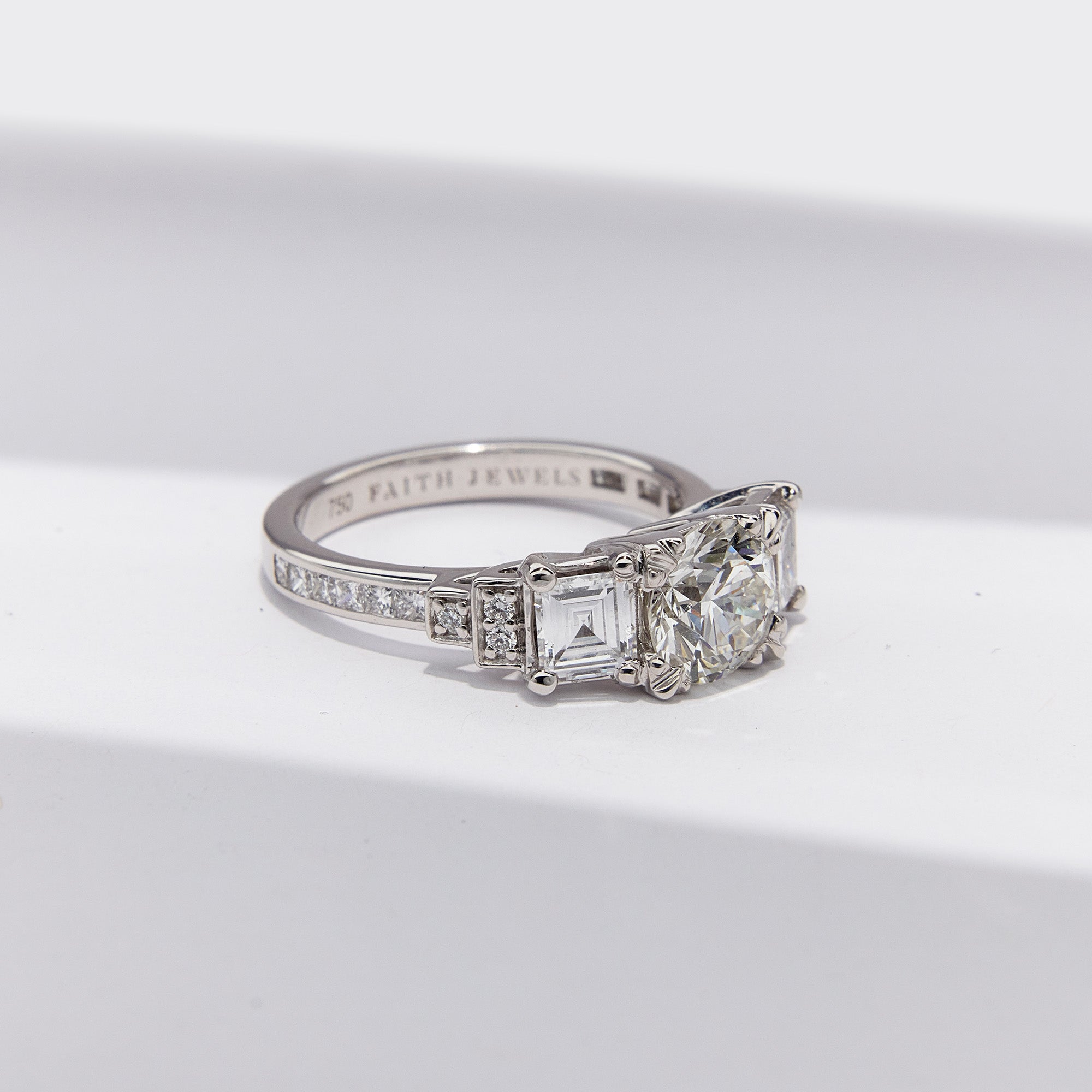 Heirloom Empire Ring with central family diamond, Art Deco trilogy design, and side diamonds in elegant setting, from side view.