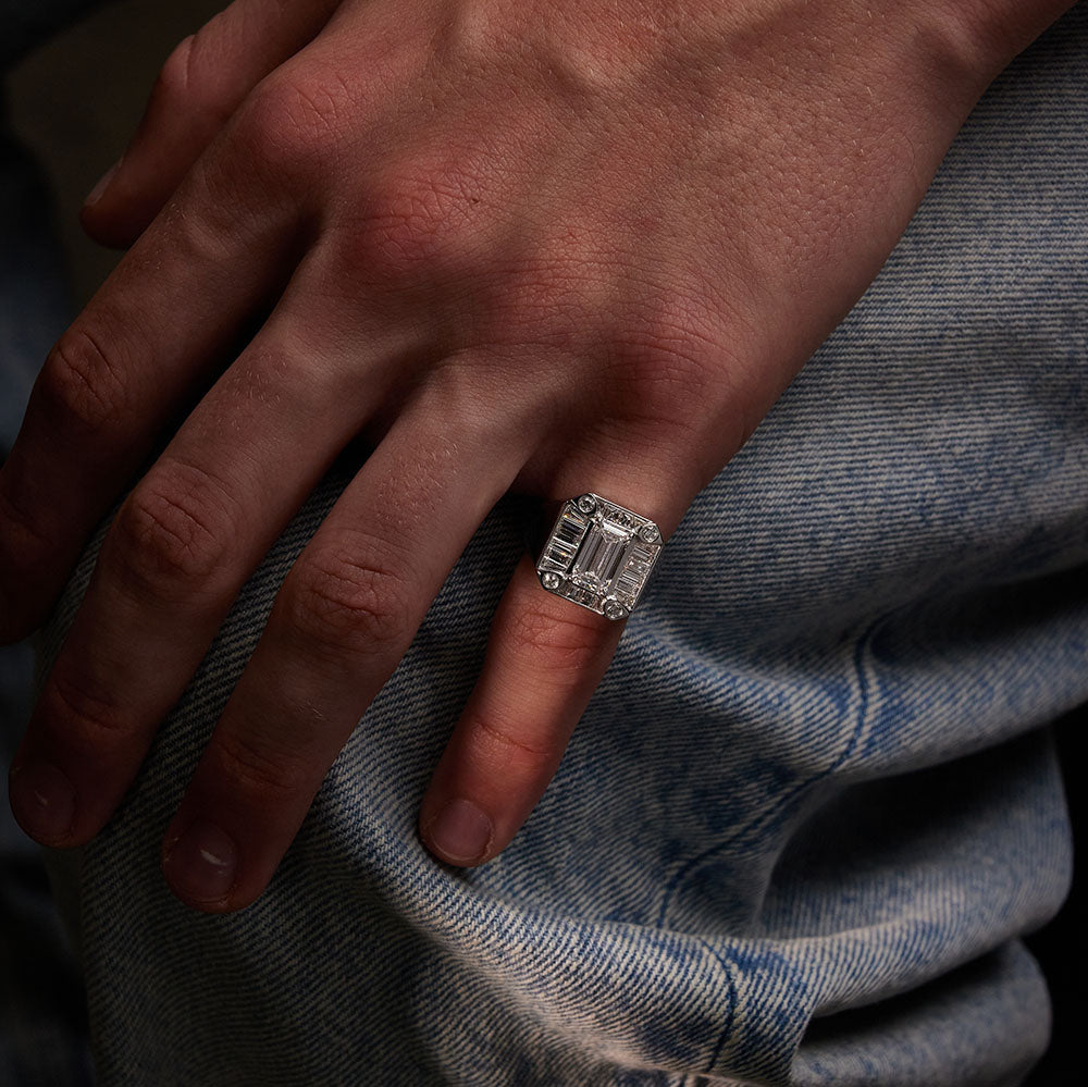 Faith Jewels White gold Gent Signet ring featuring a 1.50ct emerald-cut diamond surrounded by baguette diamonds on model.