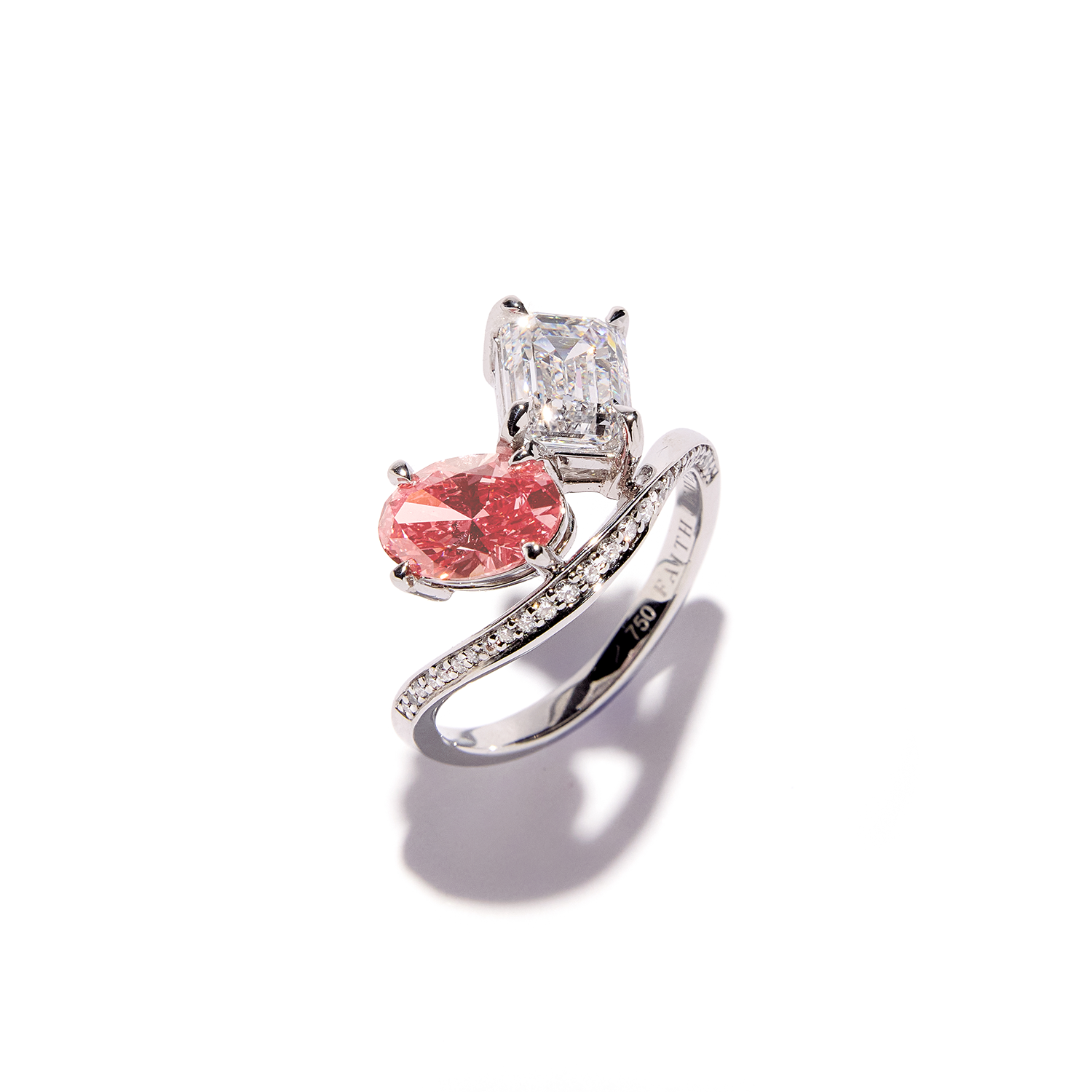 Unique Faith Jewels bespoke white gold ring with a pink oval-cut diamond and white emerald-cut diamond in an asymmetric, pavé diamond setting.
