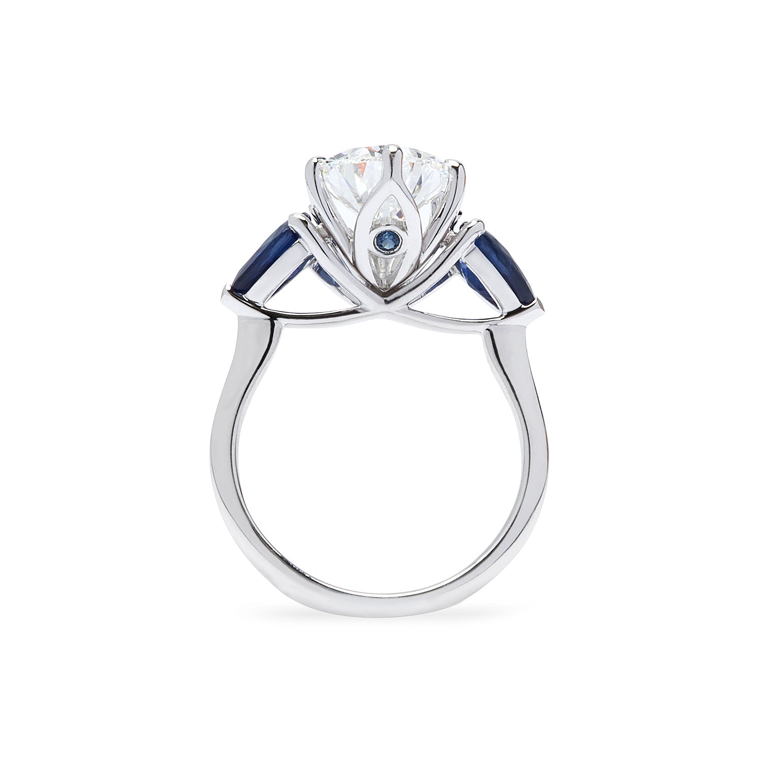 Faith Jewels Belle Époque engagement ring featuring a pear-cut diamond center, flanked by pear-cut blue sapphires, set in 18k white gold with elegant sweeping claws, accent sapphire stone seated underneath the diamond