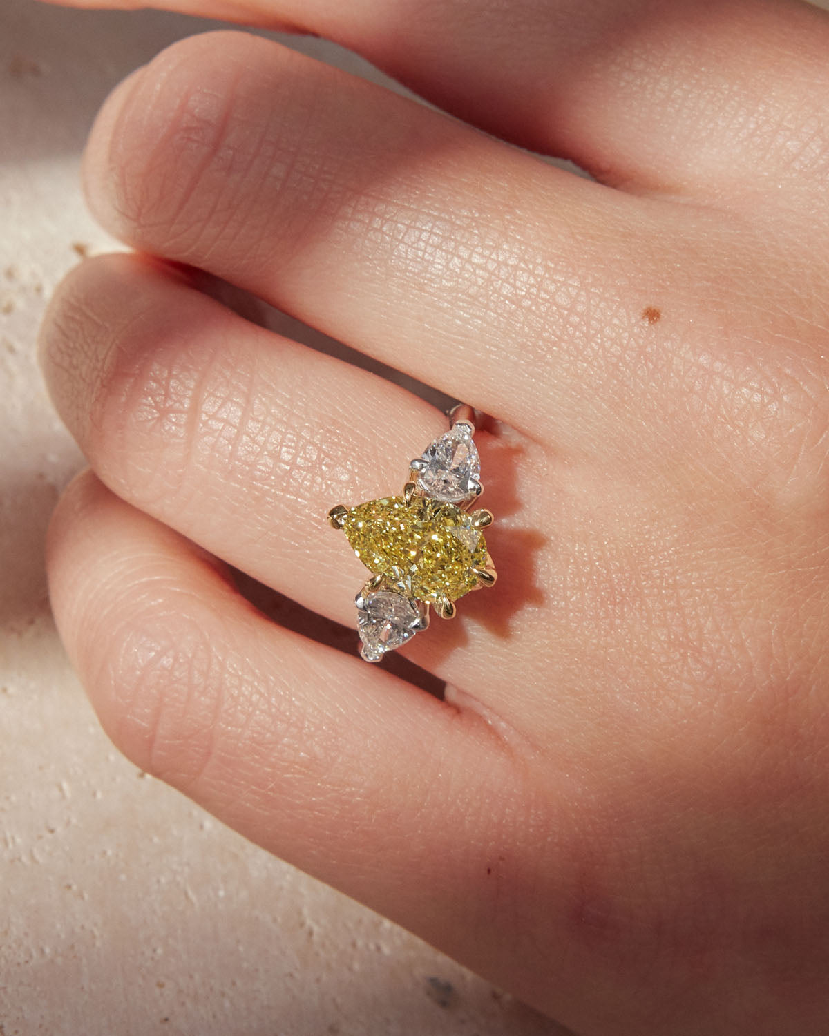 Belle Époque engagement ring with a pear-cut yellow diamond center, flanked by pear-cut white diamonds, set in 18k white gold