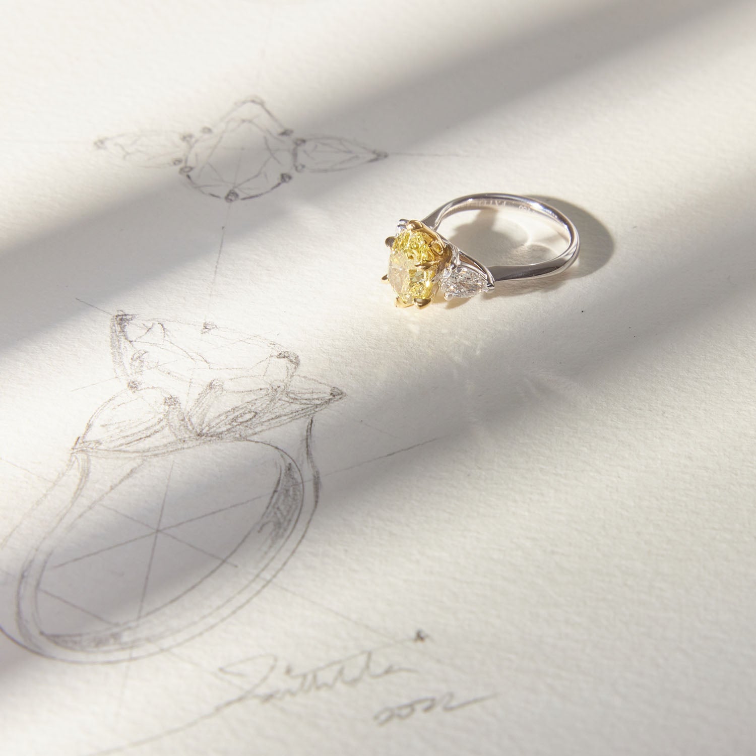 Belle Époque engagement ring with a pear-cut yellow diamond center, flanked by pear-cut white diamonds, set in 18k white gold