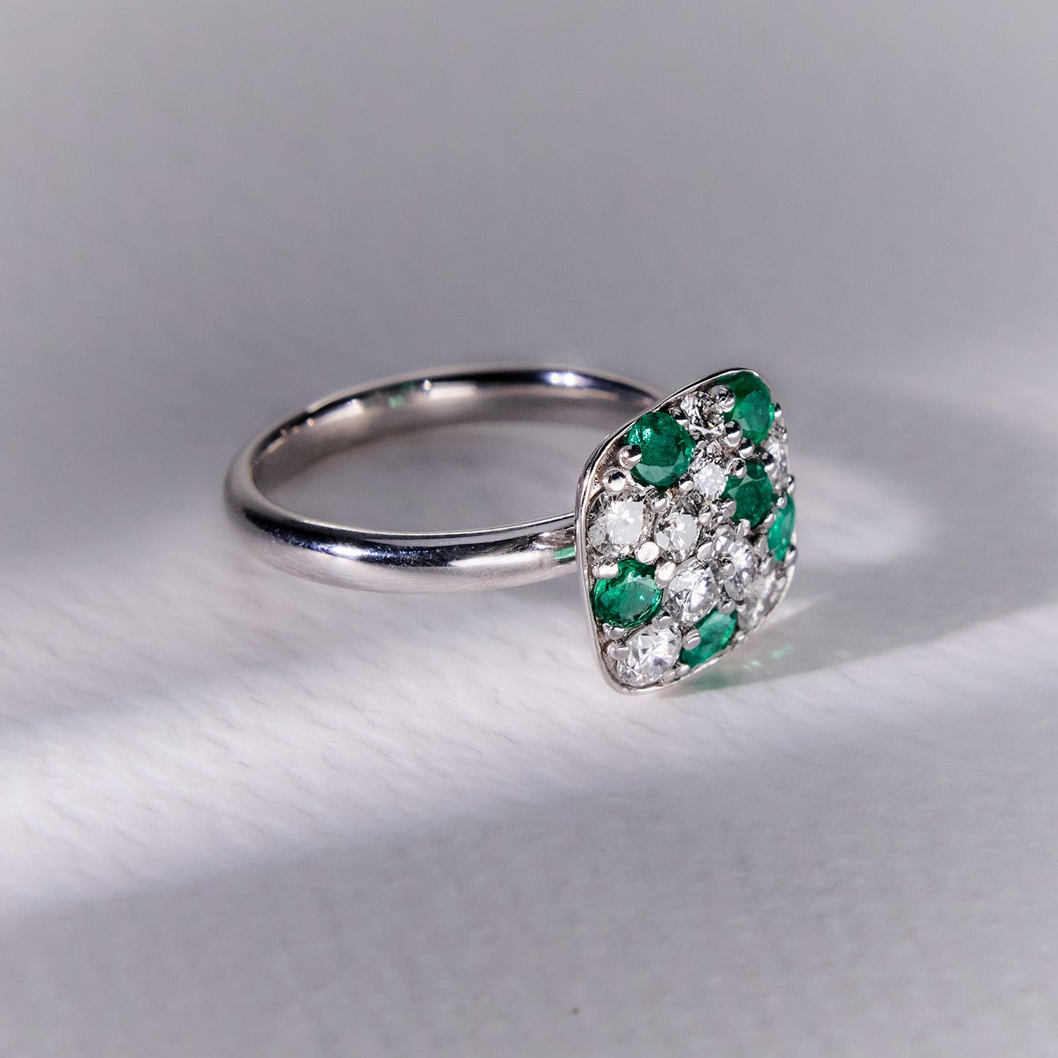 Faith Jewels 18k white gold ring featuring a mosaic-like pavé design with brilliant diamonds and vivid emeralds