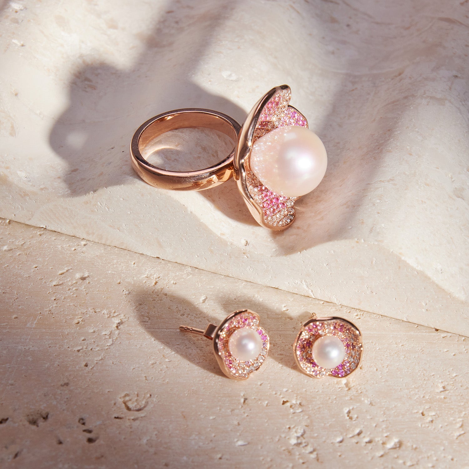 Faith Jewels Rose gold ring and earrings set with a central pearl, pink and white pavé diamonds, and petal-like design.