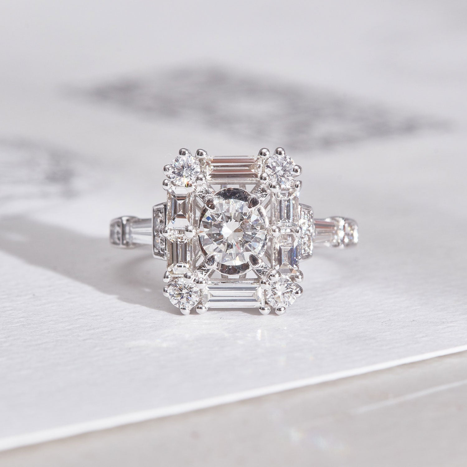 Grace aquamarine & diamond ring featuring a central diamond surrounded by baguette and brilliant-cut diamonds, set in a geometric Art Deco-inspired design