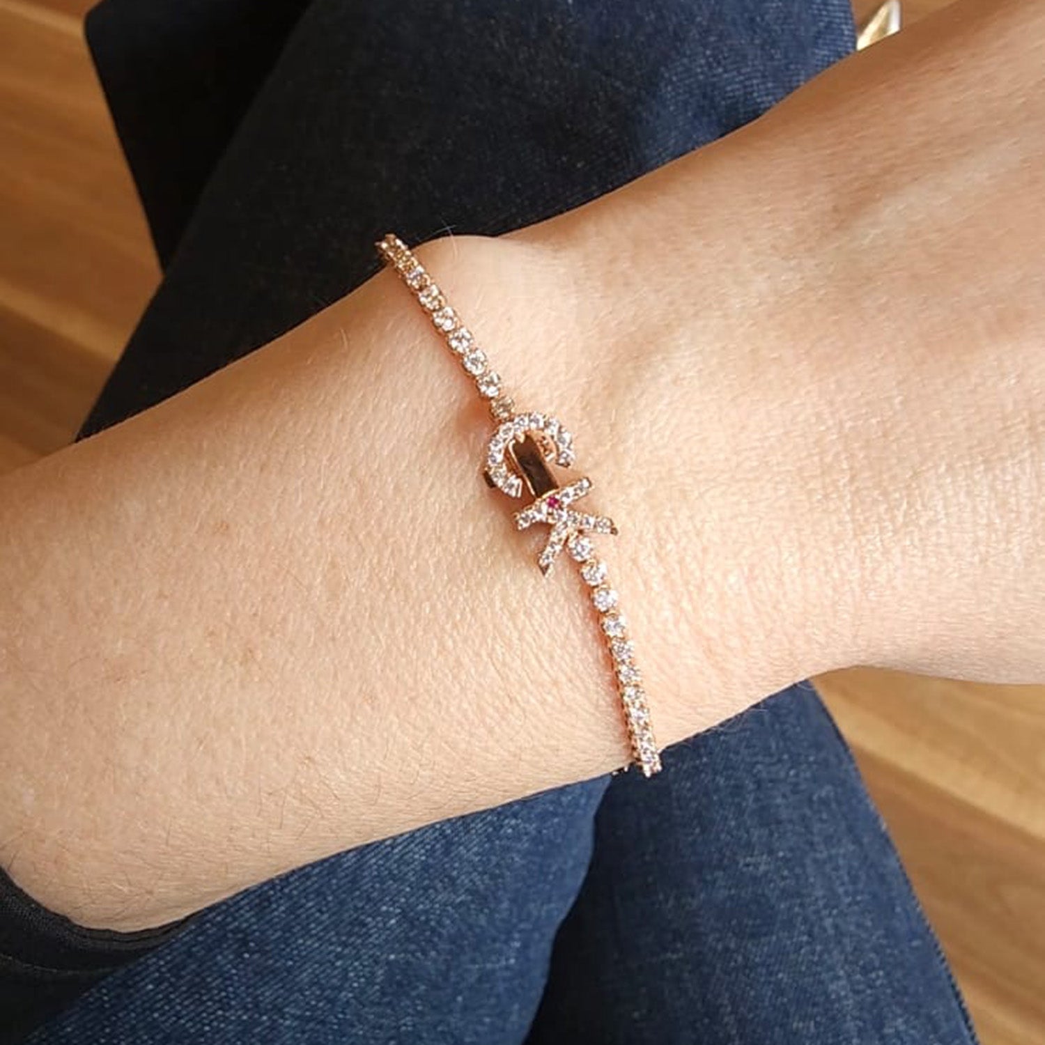 Faith Jewels bespoke initial diamond tennis bracelets in rose gold, each featuring a unique clasp shaped as a letter C and K — set with round brilliant-cut diamonds and red ruby