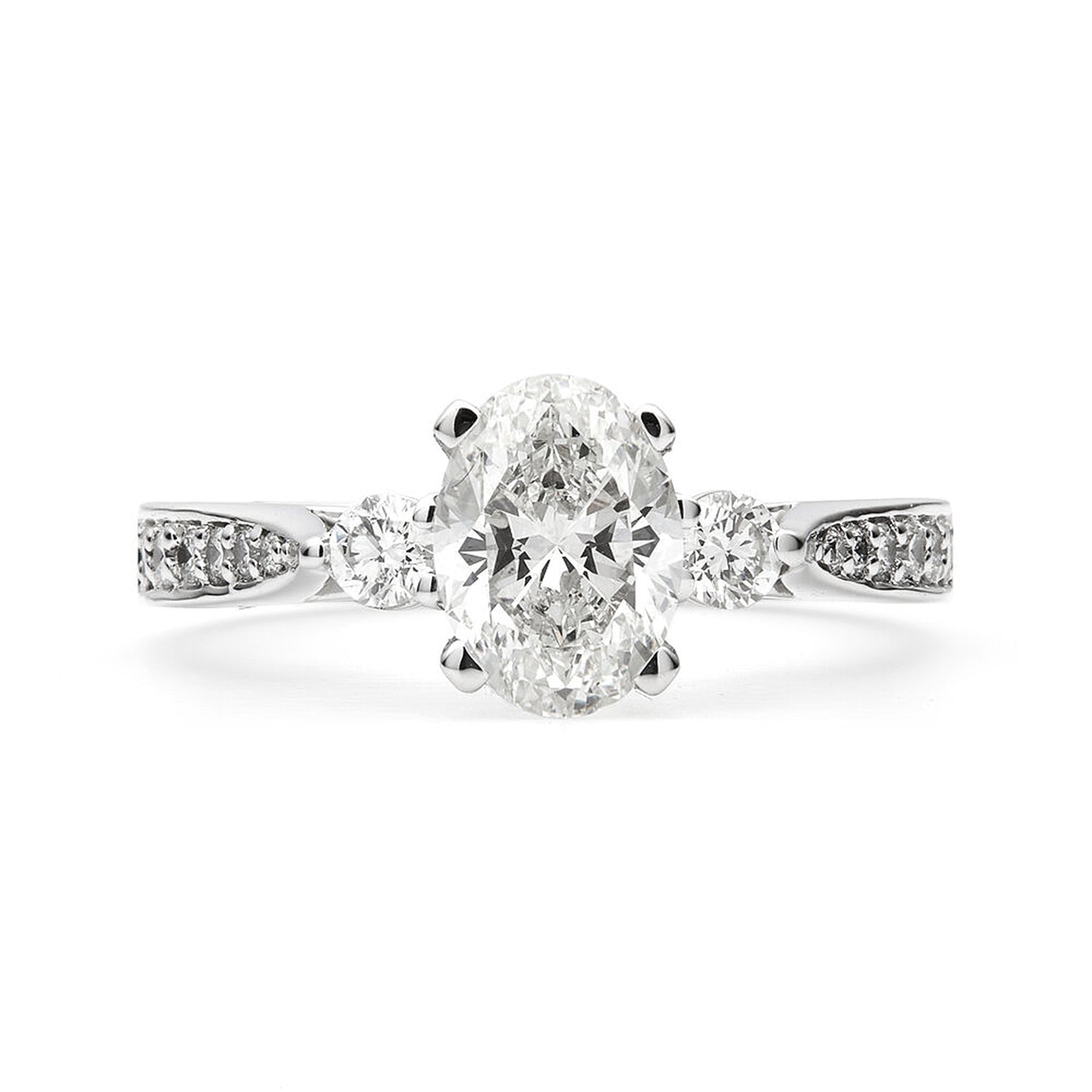 Faith Jewels Lina engagement ring with an oval brilliant-cut center diamond, flanked by two round brilliant-cut diamonds, on a tapered grain-set pavé band