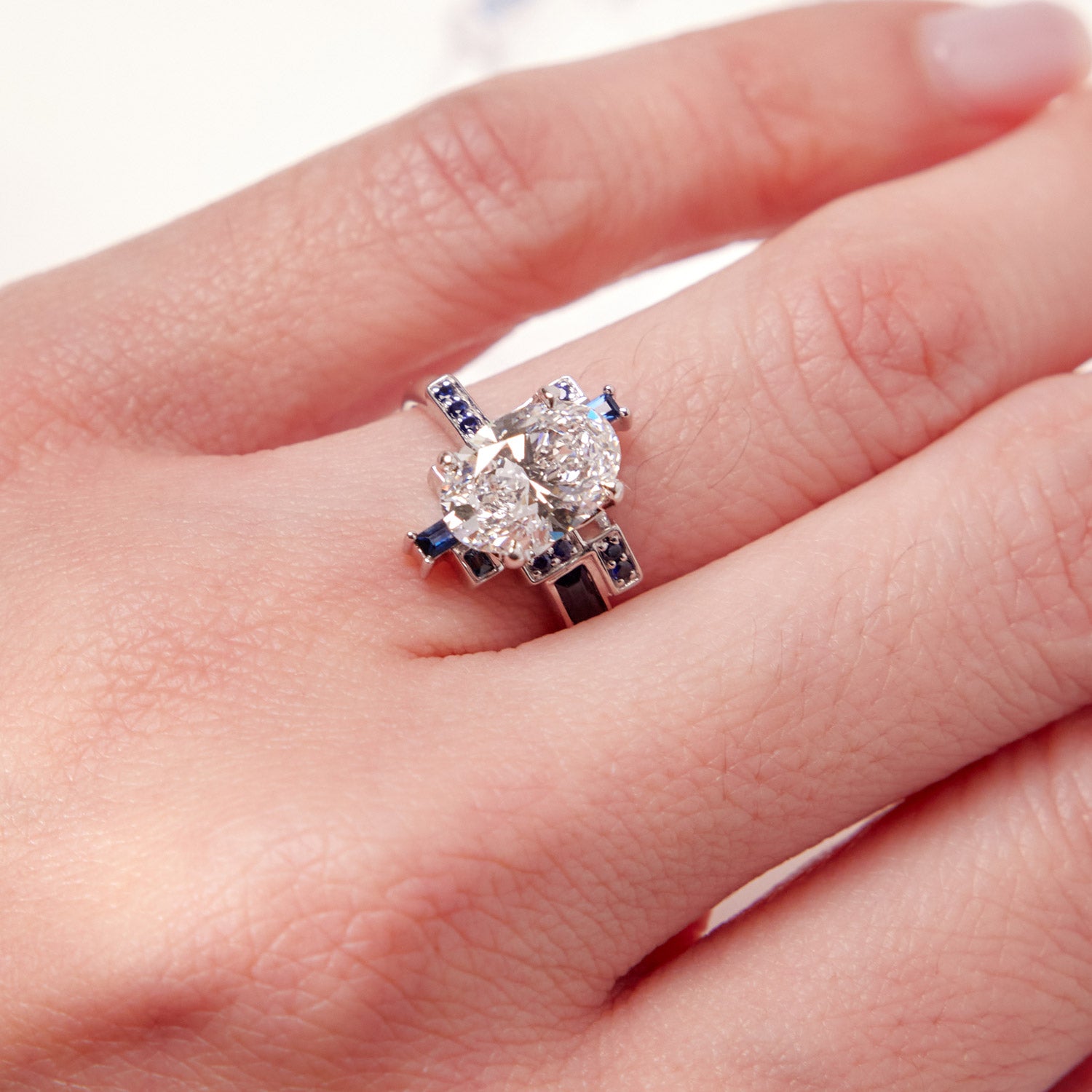 Faith Jewels Skyline Oval Diamond Ring featuring a 2ct oval-cut diamond surrounded by baguette and round blue sapphires