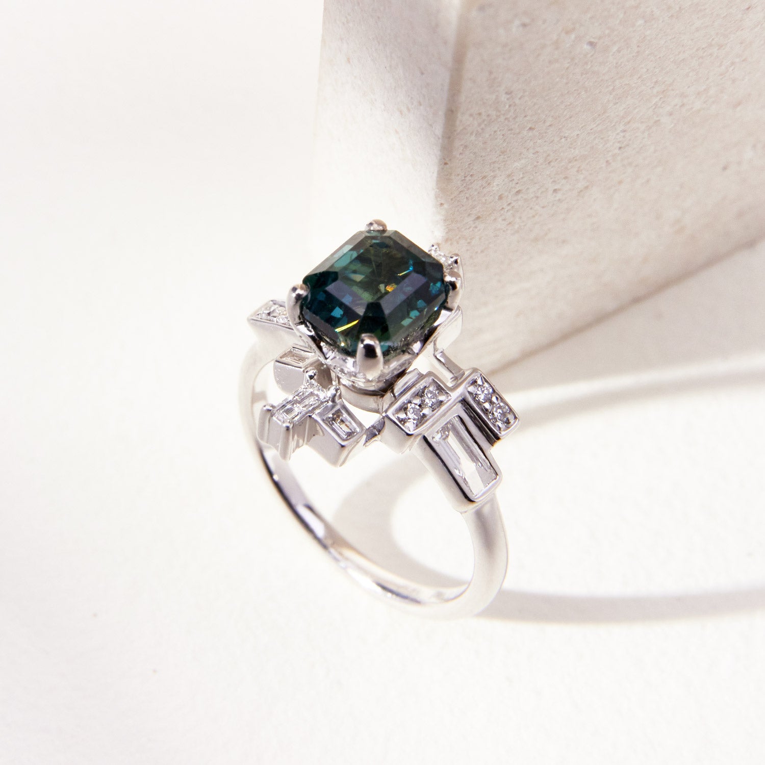 Faith Jewels Skyline ring featuring a 1.97ct teal-blue octagonal step-cut sapphire surrounded by brilliant and baguette-cut white diamonds in 18k white gold