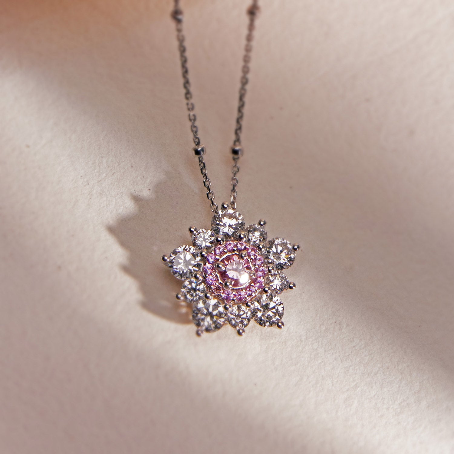 Snowflake Pendant in white gold with pink sapphire and diamond halo
